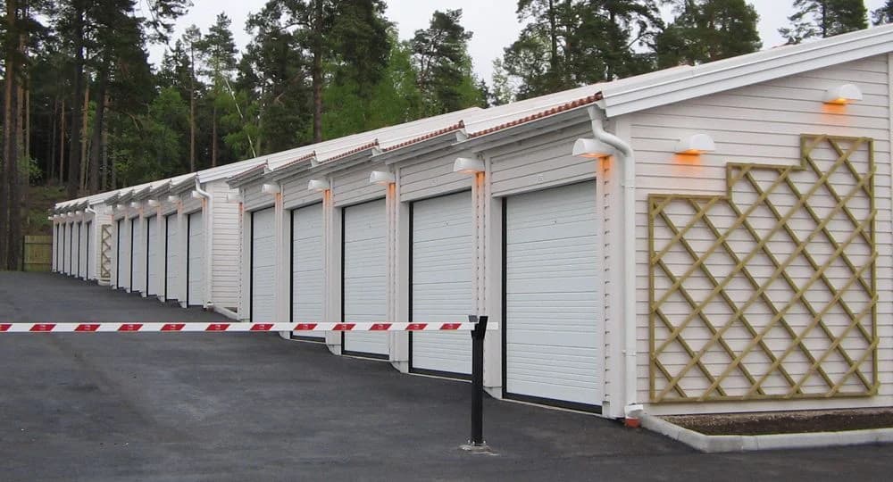 Modulbyggen med flera garageportar i en skogsmiljö.