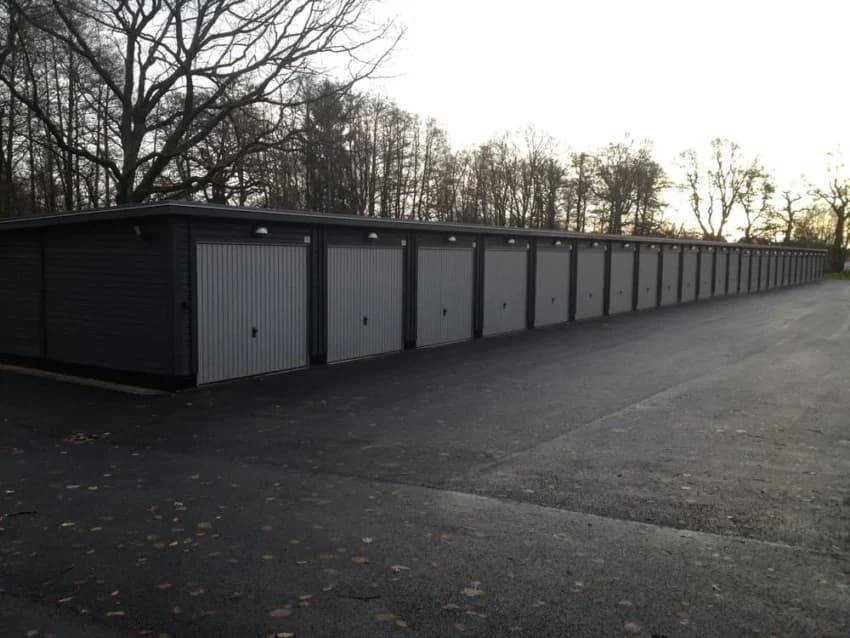 Radhus med flera garage i en asfalterad uppfart.