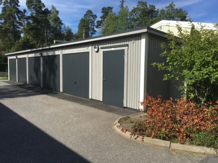 Flera garage på Krikonbacken omgivna av träd och grönska.
