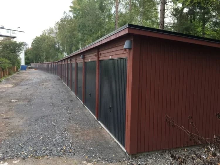 Långa rader av svarta och röda förråd i en grönskande miljö.