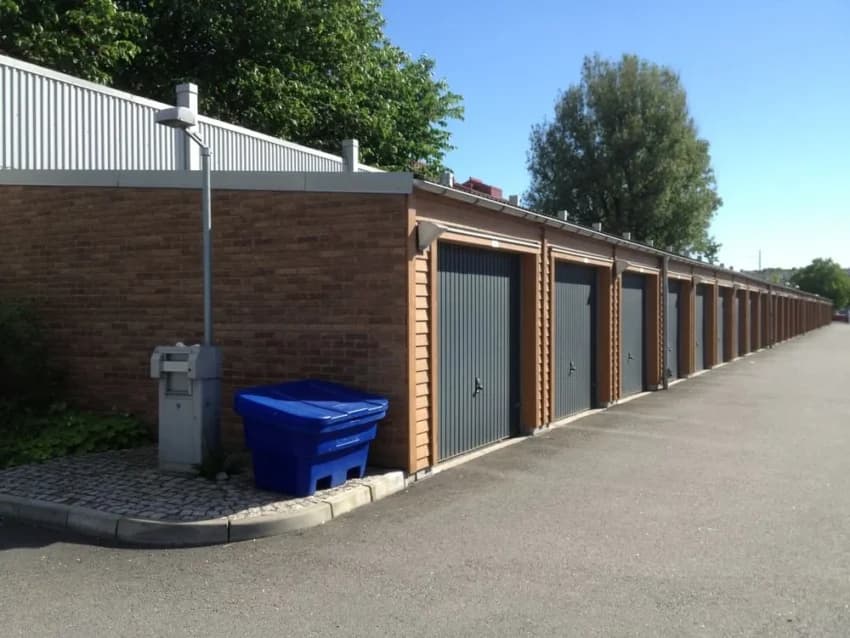 Förvaringsgarage med blå soptunna i Olskroken.