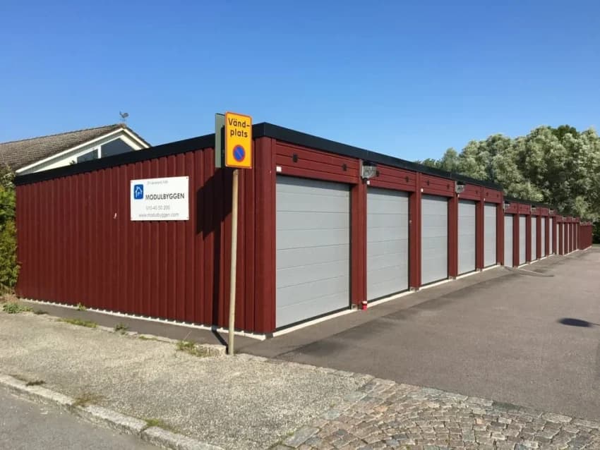 Flera röda förråd med grå dörrar vid Oxie Backar.