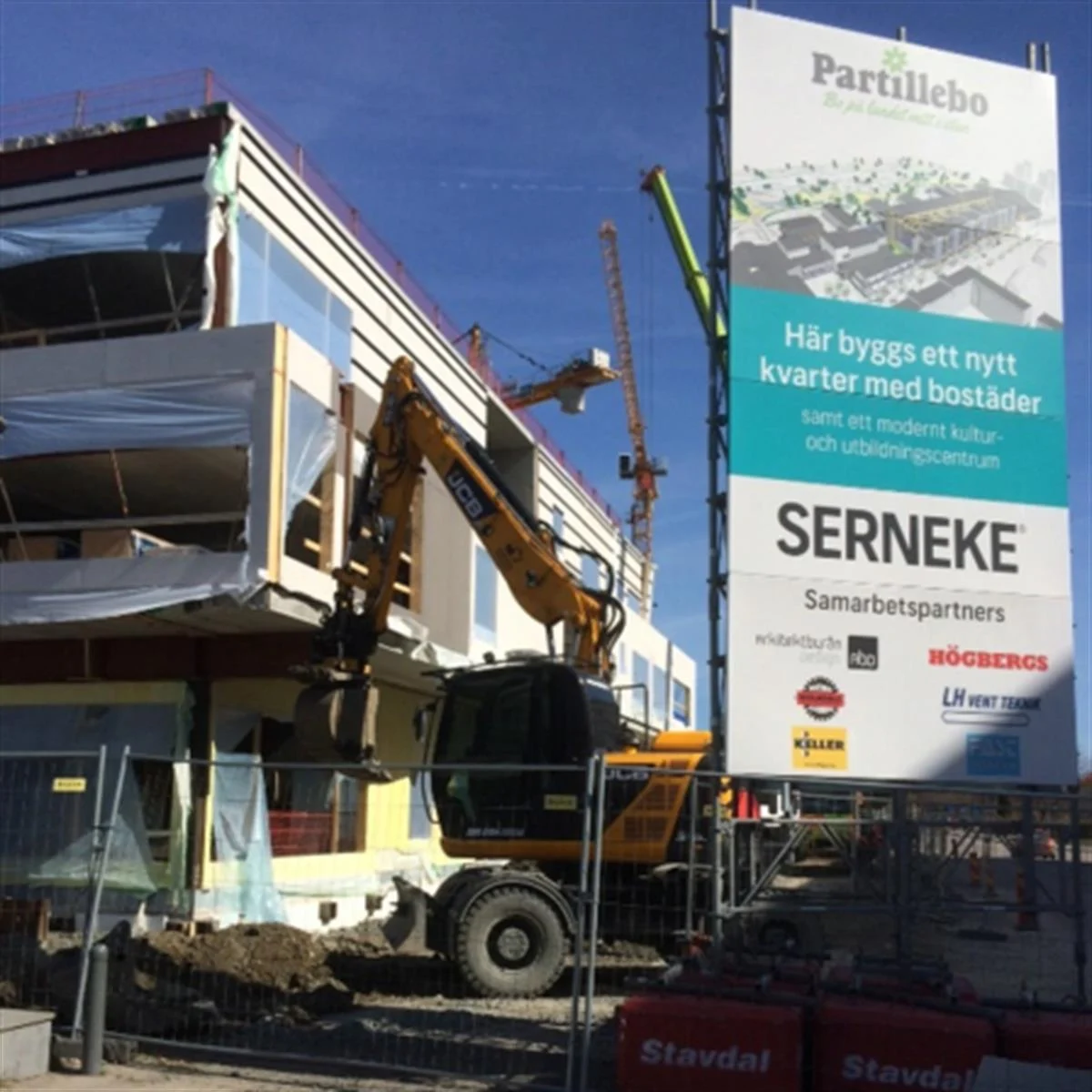 Byggarbetsplats för Partillebo med skylt och grävmaskin.