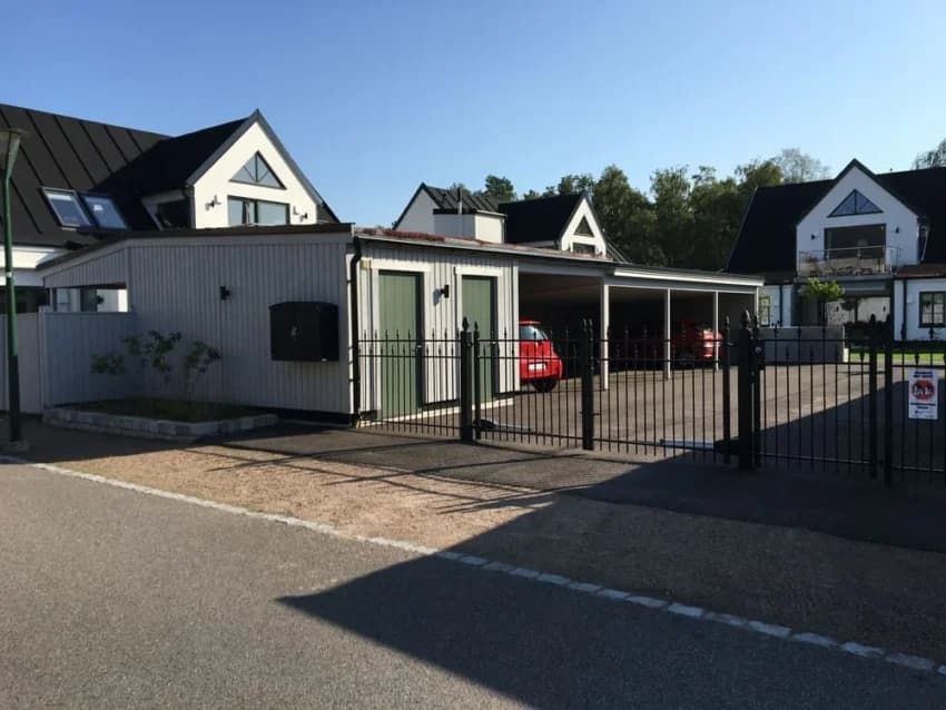 Moderna hus vid Skanörs Vångar med parkeringsplats och staket.