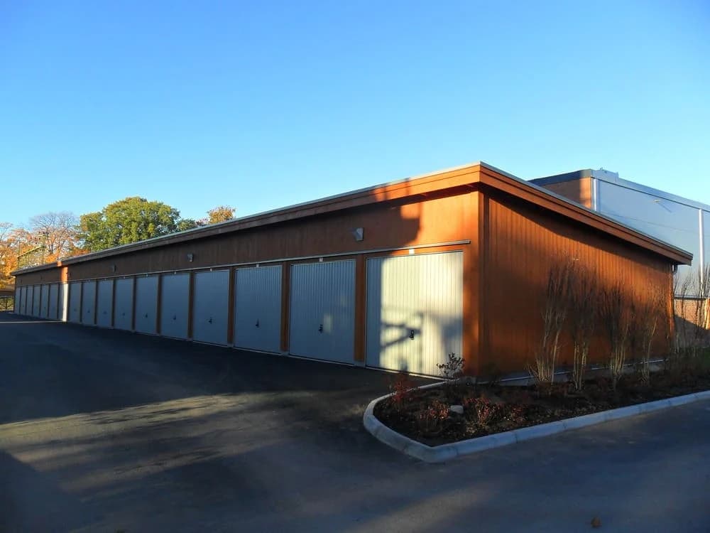 Lagerbyggnad med garageportar och blå himmel i bakgrunden.