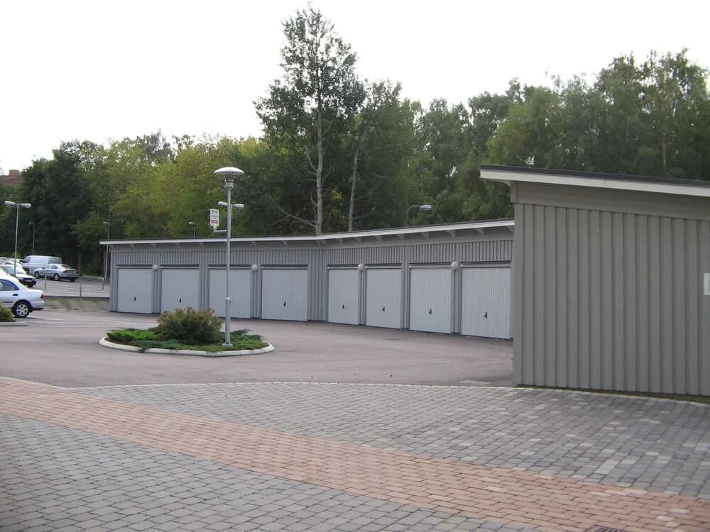 Träkilsgatan med garage och avgränsad parkeringsyta i bakgrunden.