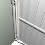 Detalj av en garageportsmekanism med hydraulisk dämpare.