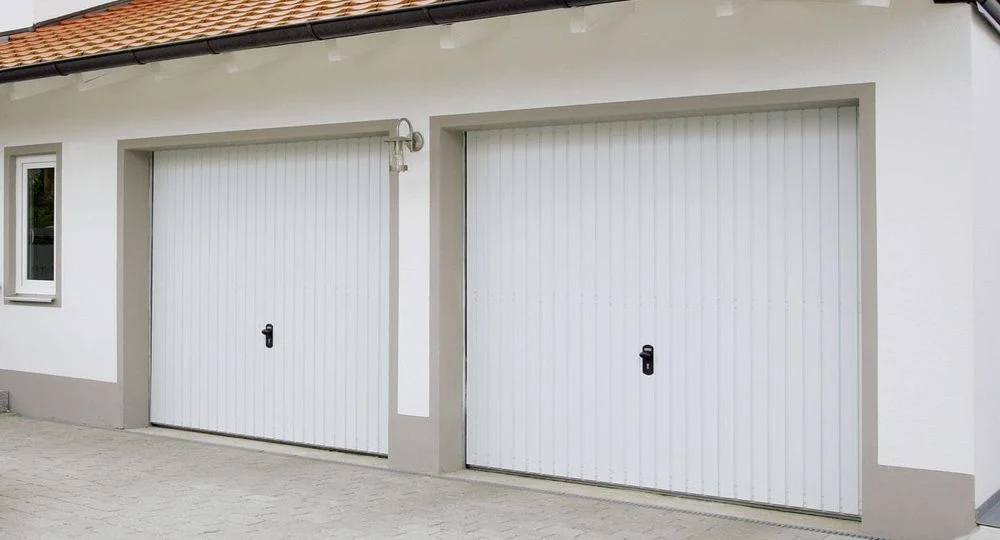 Två vita garageportar på en vit vägg.